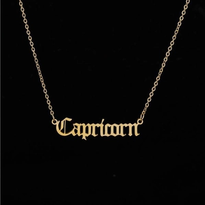 Close-up of golden Capricorn zodiac necklace with gothic style cutout lettering