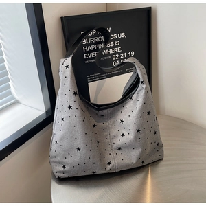 Detailed macro of grey canvas tote with black stars on a minimalist metal table