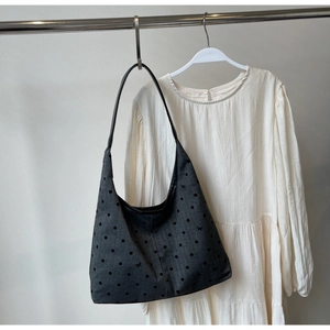 Detail of dark grey canvas tote bag featuring black polka dots and small bow patterns