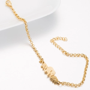 Minimalist gold stainless steel elephant charm bracelet on white porcelain display
