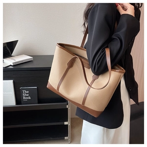 Close-up of beige lychee grain tote bag with dark brown trim and high-quality stitching