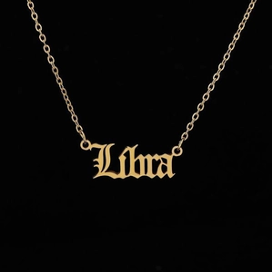 Macro detail of gold-plated stainless steel necklace with Libra zodiac gothic pendant