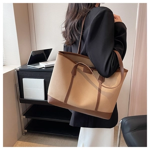 Detail of the litchi pattern tote bag featuring contrast stitching and leather texture