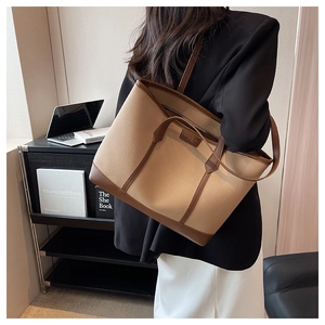 Close-up of a large tote bag with lychee texture and brown leather trim for commuting
