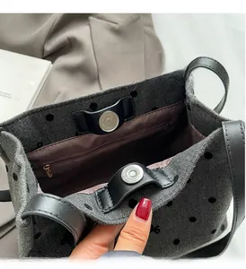 Detail of silver magnetic closure and interior zipper pocket in polka dot tote bag