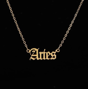 Detailed view of the gold Aries zodiac necklace with vintage old English lettering