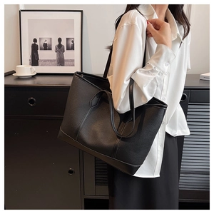 Detailed view of the black lychee grain texture and soft leather on the tote shoulder bag
