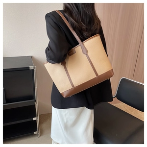Close-up of contrast color tote bag showing lychee grain leather and shoulder strap detail
