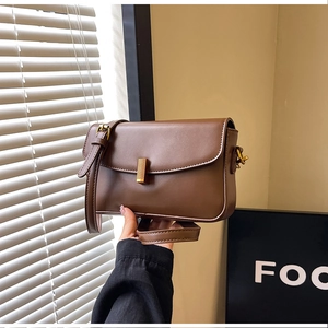 Detail of dark brown retro crossbody bag featuring a vintage gold rectangular metal buckle