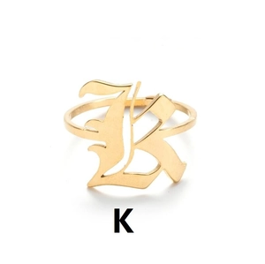 Detail eines goldenen Edelstahlrings im Vintage-Stil mit gotischem Buchstaben K