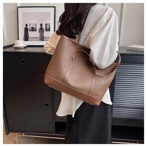 Detailed view of brown litchi grain tote bag with reinforced edges and slim straps