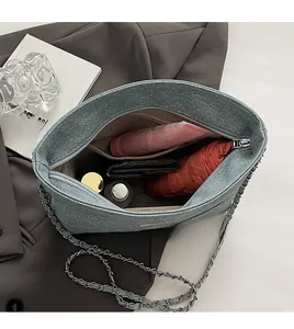Internal view of the denim crossbody bag showing large capacity and zipper pocket