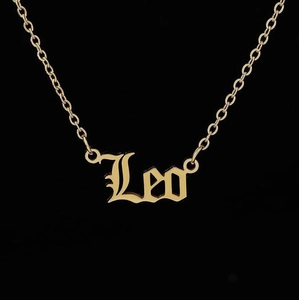 Macro shot of gold-plated Leo zodiac pendant with gothic lettering and O-link chain