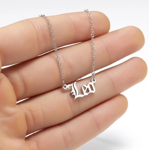 Detailed close-up of a silver Leo nameplate necklace featuring gothic font and fine chain