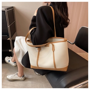 Chic cream white litchi pattern tote bag with brown straps shown on a model