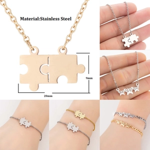 Detailed view of puzzle piece pendant and butterfly necklace in stainless steel