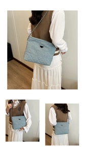 Detail of light blue denim nylon crossbody bag with triangle metal logo and chain strap