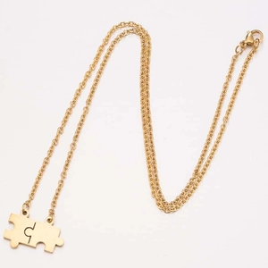 Minimalistische goldene Puzzle-Halskette mit feiner Gliederkette auf weißem Hintergrund