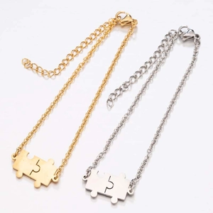 Detail of interlocking jigsaw puzzle pendants in gold and silver with adjustable chains