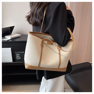 Close-up of minimalist lychee pattern tote bag with contrast stitching and brown straps