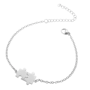 Detail of silver puzzle piece pendant on stainless steel chain with lobster clasp