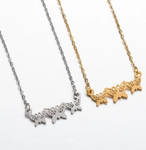Close-up of butterfly pendant necklaces in gold and silver finishes on a simple link chain