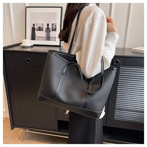 Detailed view of large lychee texture tote bag carried on shoulder for commuting