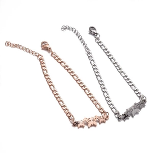 Close-up of rose gold and silver butterfly charm bracelets with Figaro chain and lobster clasp