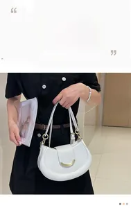Detail of white crescent shoulder bag with golden metal buckle and smooth leather finish