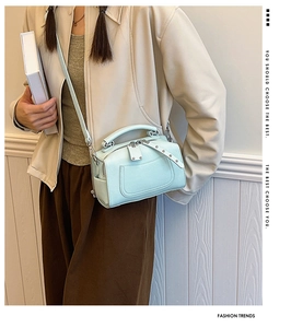 Detail of mint green Boston bag in pebbled leather with silver hardware and shoulder strap