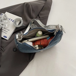 Blue denim baguette shoulder bag with silver leather trim showing large interior capacity