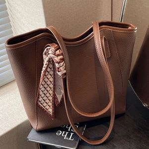 Minimalist brown lychee leather tote bag with geometric silk scarf for daily commute