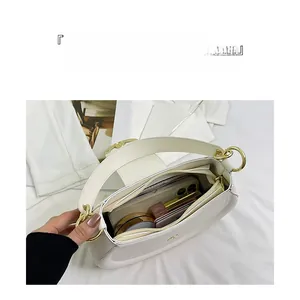 Interior view of white leather crescent bag showing large capacity and multi-layer pockets