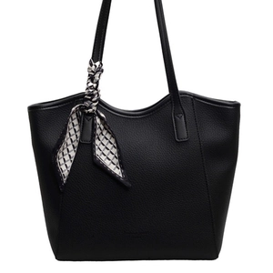 Minimalist black pebble leather tote bag with geometric silk scarf on handles