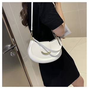 Detailed view of the white crescent bag with golden buckle on a shoulder model