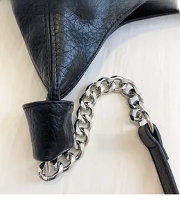 Close-up of black litchi grain leather tote with sturdy silver chain strap and polished hardware