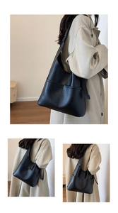 Grand sac cabas noir en cuir grainé avec boucle en métal porté dans un décor intérieur
