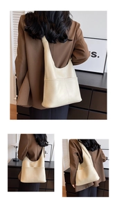 Détail de la texture grainée douce et de la poche avant sur ce sac fourre-tout blanc crème