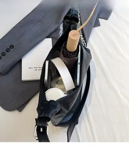Macro view of spacious interior of black tote bag showing headphones and tablet storage
