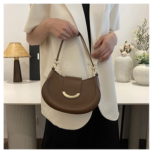 Detail view of dark brown half-moon underarm bag with elegant gold metal hardware