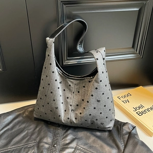 Polka dot canvas tote bag with black bow details and leather shoulder straps for daily commute