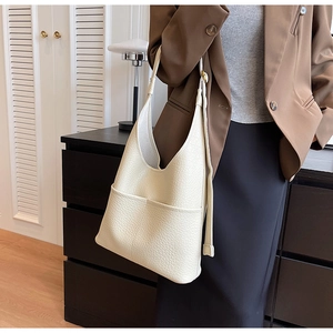 Gros plan du sac hobo crème montrant la texture du cuir et la large bandoulière