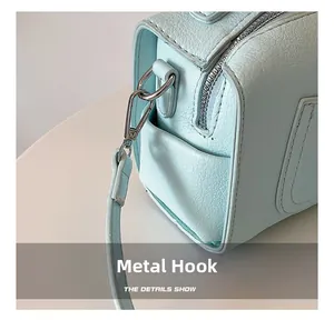 Detail of premium silver metal hardware hook on light blue textured leather bag