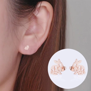 Detail of rose gold rabbit stud earrings featuring a delicate hollowed-out animal design