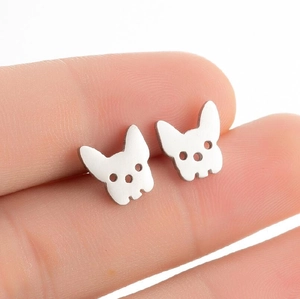 Macro shot of minimalist silver bulldog head silhouette stud earrings held in hand