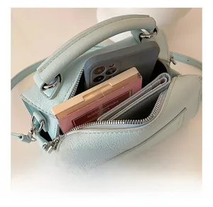 Macro view of light blue leather Boston bag showing spacious internal capacity for essentials