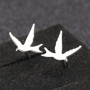 Minimalist silver stainless steel bird stud earrings featuring a flying swallow design