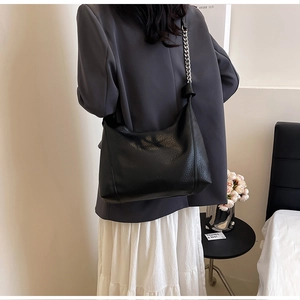 Detail of black lychee grain PU leather hobo bag with stylish silver metal chain strap