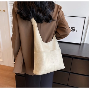 Gros plan du sac bandoulière blanc crème en cuir grainé avec coutures précises