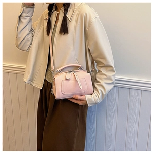 Pink lychee grain Boston bag shown with adjustable shoulder strap on a model